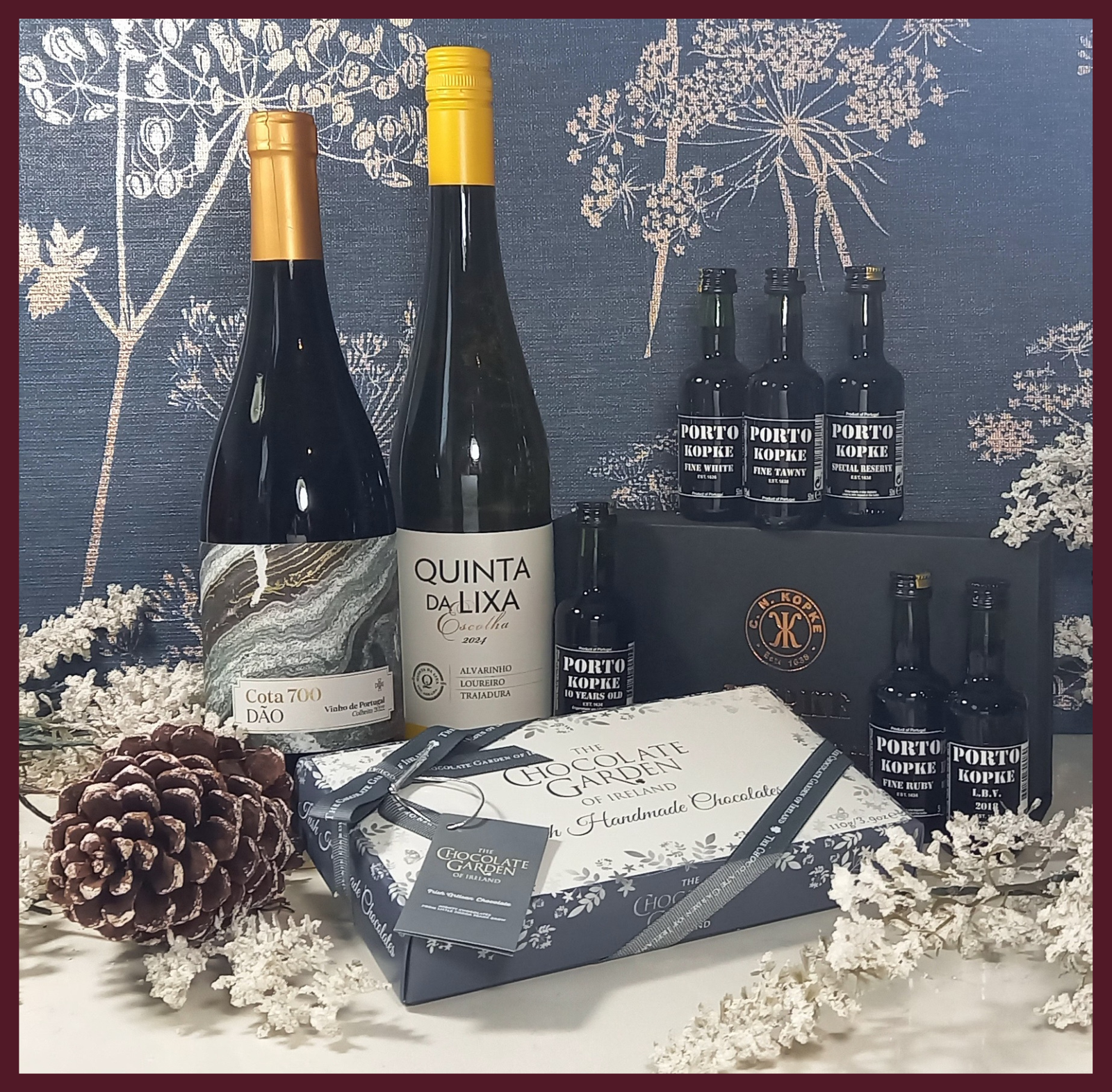 Wine bottles and a gift box with chocolates on a decorative background